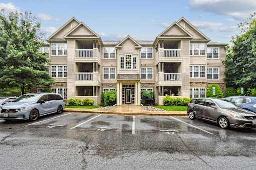 A large apartment complex with a parking lot in front.
