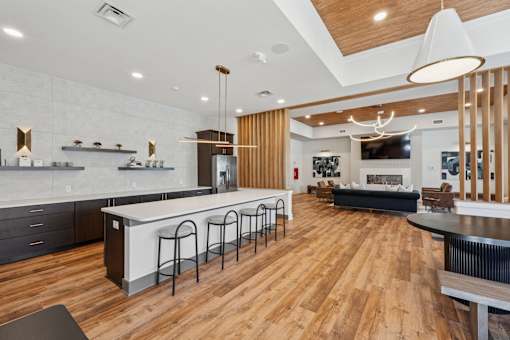 A modern kitchen with a bar area and a living room in the background.