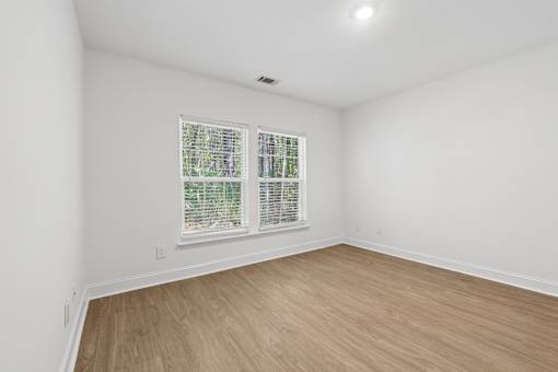 A room with a window and wooden flooring.