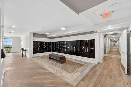 A long hallway with a bench and a black board on the wall.