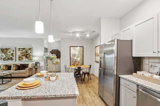 A kitchen with a granite countertop and stainless steel appliances.