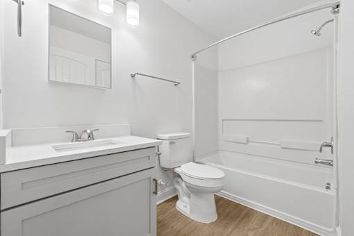 A white bathroom with a toilet, sink, and bathtub.