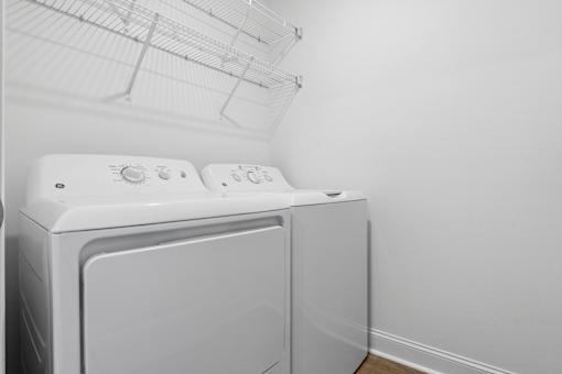 Two white front loading washing machines in a laundry room.
