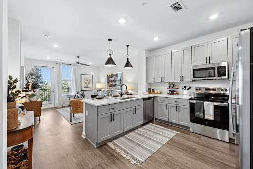A modern kitchen with a large island and stainless steel appliances.