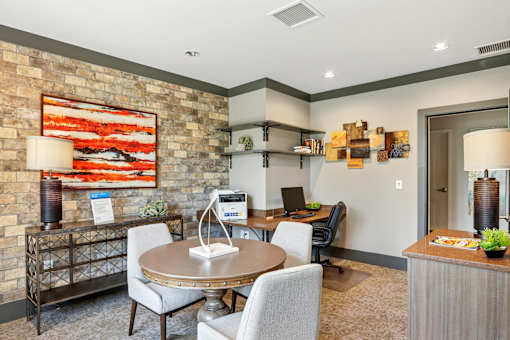 A room with a table and chairs and a painting on the wall.