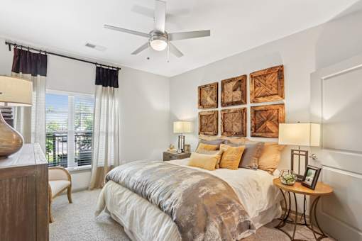 A bedroom with a large bed and a ceiling fan.