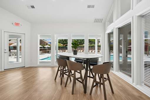 A dining room with a white table and chairs.