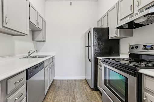 A kitchen with a black refrigerator, stove, and oven.