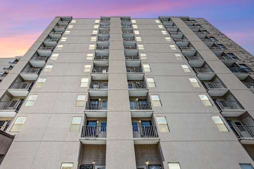 A tall residential building with balconies on each floor.