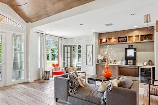 A living room with a grey couch and a wooden ceiling.