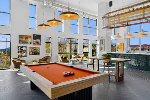 A pool table is in the middle of a room with a view of the mountains.