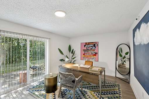 A room with a desk, chair, and a poster on the wall.