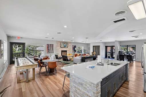A kitchen with a large island and a dining table with chairs.