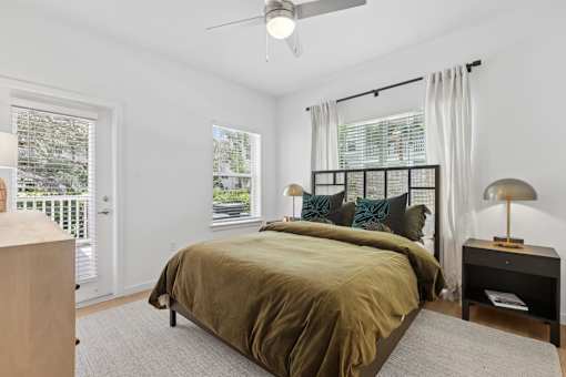 A bedroom with a bed, nightstand, and window.