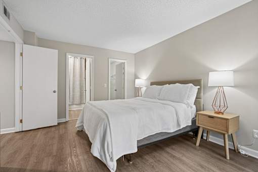 A bedroom with a bed, nightstand, and lamp.