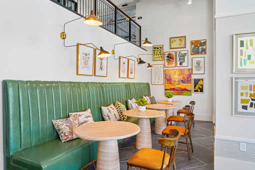 A restaurant with green booths and wooden tables.