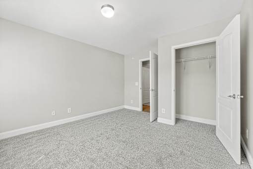 A room with a grey carpet and white walls.