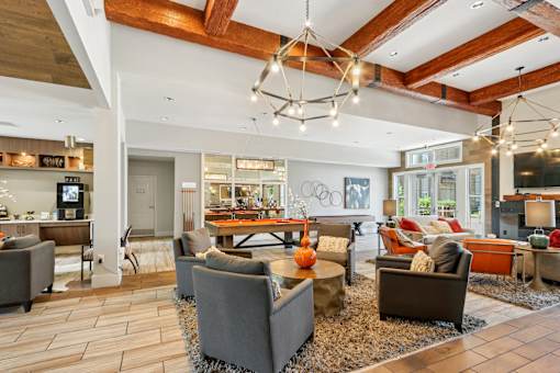 A modern living room with a wooden ceiling and a variety of seating options.