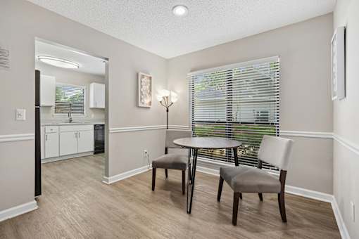 A dining room with a table and two chairs.