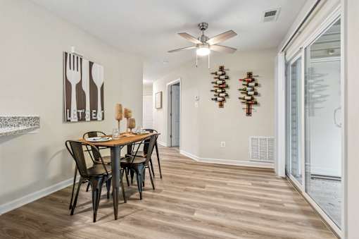 A dining room with a wooden table and chairs.