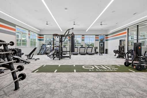 A gym with a variety of equipment including weights and cardio machines.