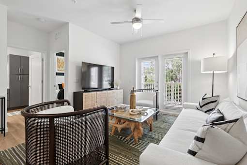 A living room with a white couch and a wooden coffee table.