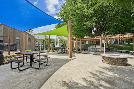 A park with a picnic table and a green shade sail.