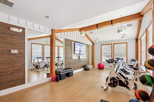 A room with a wooden wall and a row of exercise equipment.