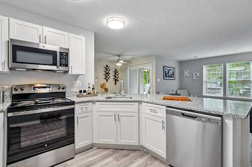 A kitchen with white cabinets and a black stove top oven.
