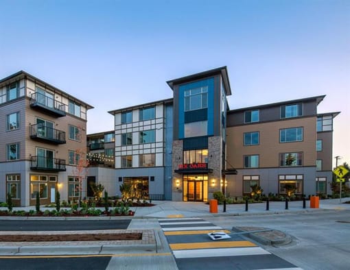 a street view of an apartment building at dusk