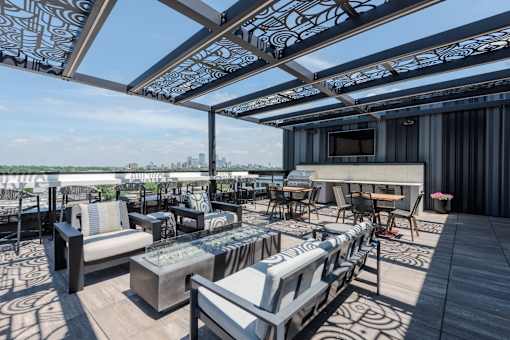 A patio with a table and chairs under a patterned awning.