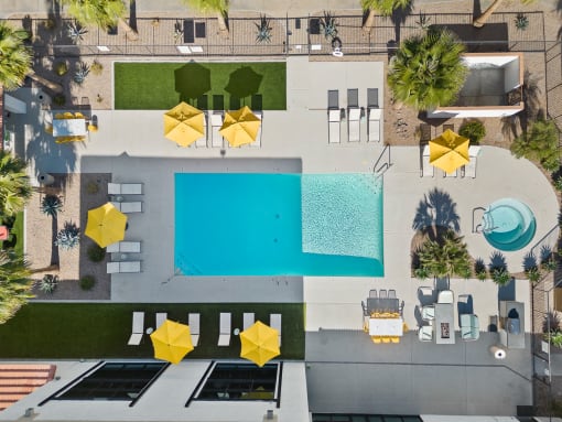 arial view of a swimming pool and patio with umbrellas