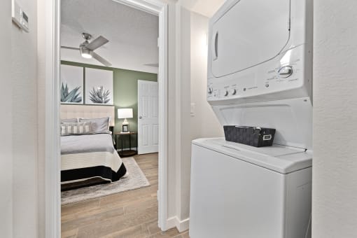 a white washer and dryer in a room next to a bedroom