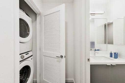 A white washing machine is in a small laundry room.