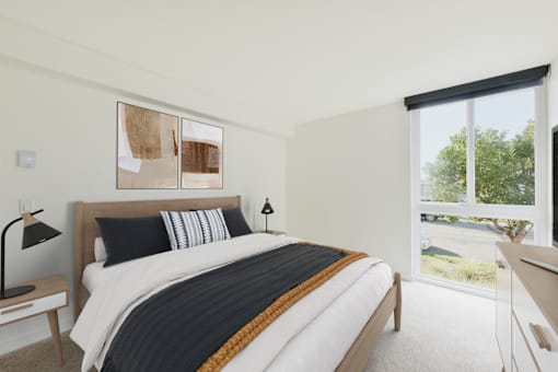 A bedroom with a large bed and a window overlooking a green area.