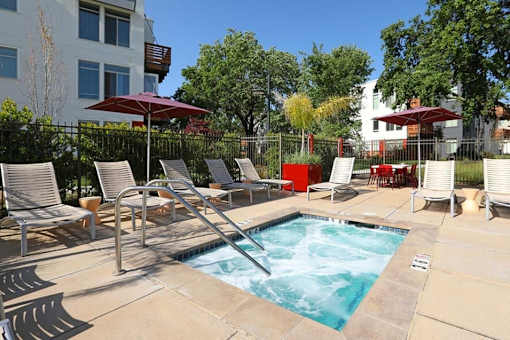 A pool surrounded by chairs and umbrellas.