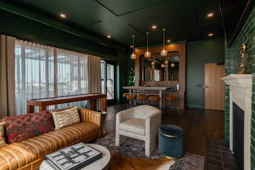 A living room with a couch, chair, and fireplace.