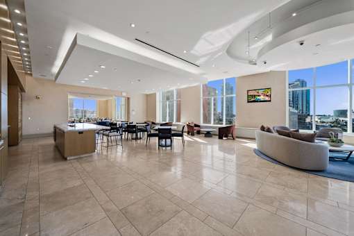 A spacious living room with a large window overlooking the city.