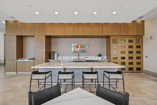 A kitchen with a dining table and chairs in the foreground.