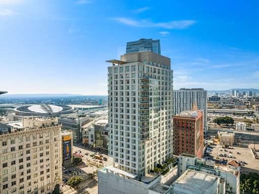 A modern glass building stands tall in a cityscape.