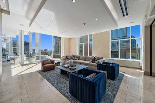 A spacious living room with a large window overlooking the city.