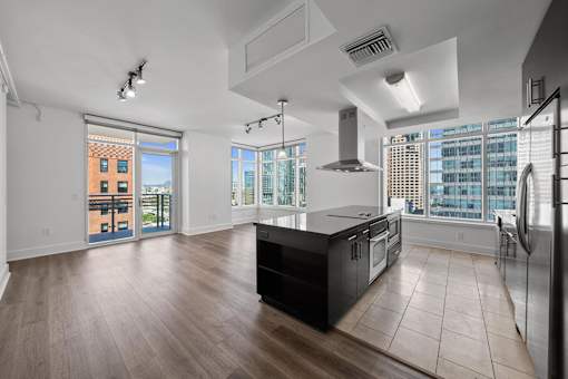 A modern kitchen with a large island and stainless steel appliances.