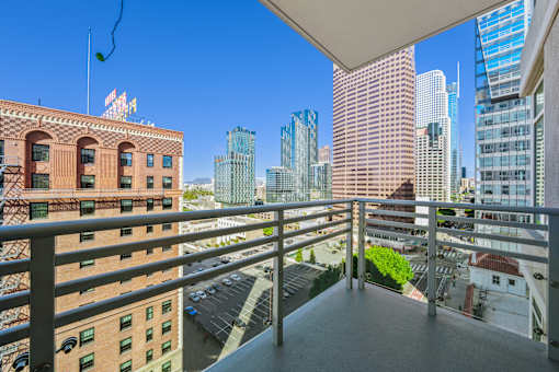 A balcony overlooks a cityscape with a mix of modern and older buildings.