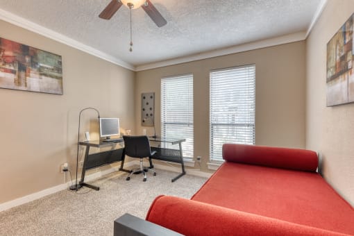 a bedroom with a bed and a desk with a computer
