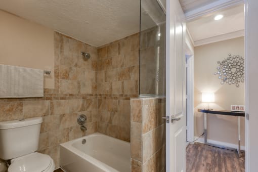 a bathroom with a white toilet next to a bathtub
