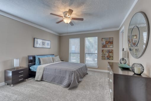 a bedroom with a bed and a ceiling fan