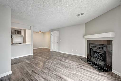 A living room with a fireplace and wood flooring.