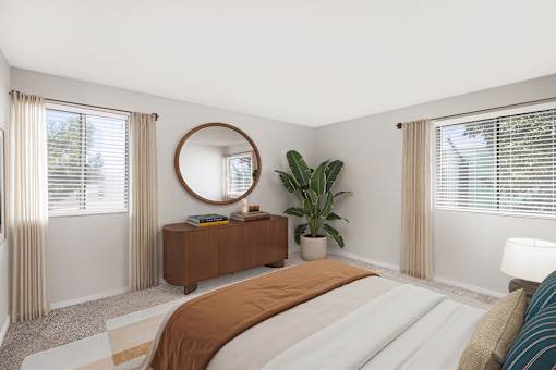 A bedroom with a large bed and a round mirror on the wall.
