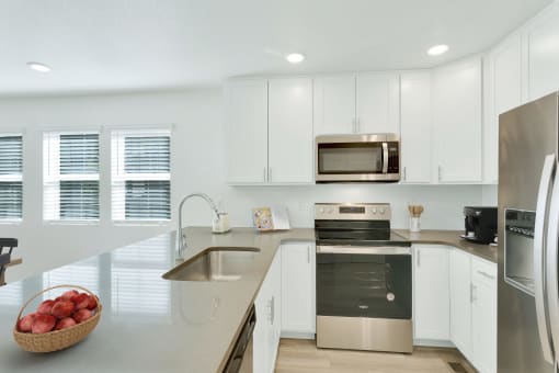 a kitchen with white cabinets and stainless steel appliances
