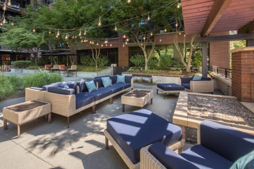 a patio with couches and chairs and a fire pit